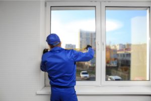 Worker Repairing Window in House